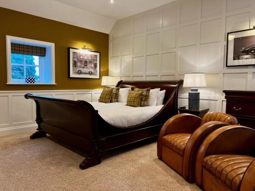 斯卡伯勒花冠馆乡村之屋餐厅酒店的一间卧室配有一张床、一张沙发和一把椅子