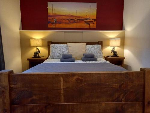 科尔切斯特Donkey & Buskins的一间卧室配有一张带两盏灯的大木床。
