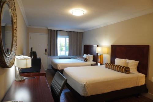 圣巴巴拉玫瑰花园汽车旅馆的酒店客房,设有两张床和镜子