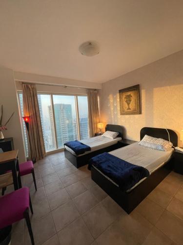 迪拜Travelers Backpackers的一间卧室设有两张床和大窗户