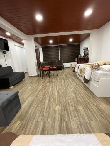 巴尼奥斯Bello apartamento en Baños de Agua Santa的配有一张床和一张桌子及椅子的房间