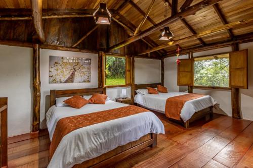 萨兰托Ecohotel Piedemonte的客房设有两张床铺、木制天花板和窗户。