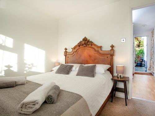 金斯布里奇Waterside Park Annexe的一间卧室配有一张大床和木制床头板