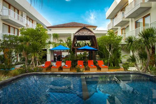 沙努尔阿维安华美伦酒店 的游泳池,带椅子和遮阳伞