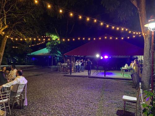 阿瓜奇卡Cabaña Villa Mary-Aguachica的一群人坐在帐篷里,坐在椅子上,灯火通明