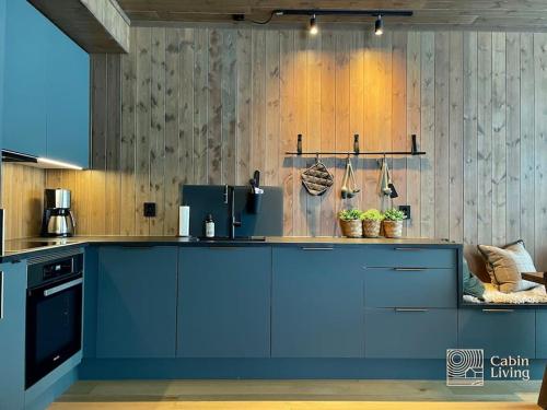 奥耶Brand new Chalet-apart slope Hafjell Mosetertoppen的一间厨房,在房间内有一个蓝色的小岛