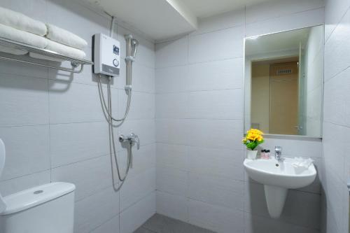 新加坡Sandpiper Hotel Singapore的带淋浴和盥洗盆的白色浴室