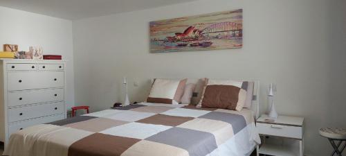 拉普拉亚蒂陶洛Villa Tauro Beach & Golf的卧室配有一张床,墙上挂有绘画作品