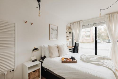 阿姆斯特丹Luxurious Private Studio Amsterdam Zuid的一间卧室配有一张床,上面放着一个食物托盘