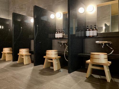 草津Urakusatsu TOU的浴室设有四把凳子、淋浴和镜子