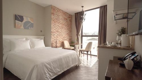 胡志明市Celine Living - Central的卧室配有白色的床和砖墙