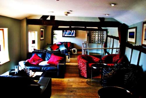 南特威奇柴郡之猫酒店的带沙发和红色枕头的客厅