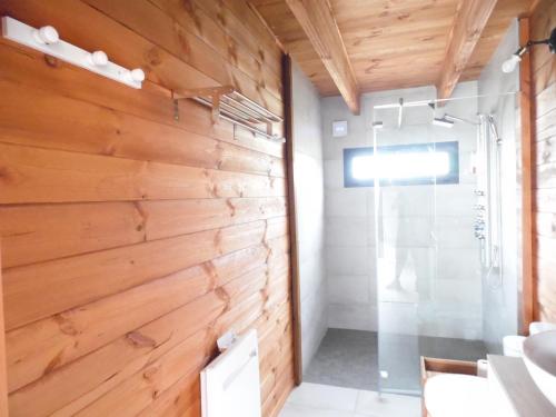 杜埃拉丰坦Chalet cosy climatisé avec parking et Internet的一间带木墙和淋浴的浴室