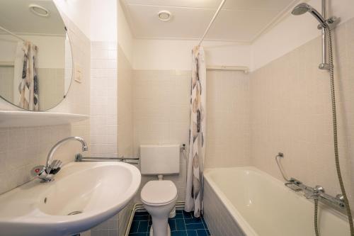 德科赫Appartementen Beatrix的浴室配有盥洗盆、卫生间和浴缸。
