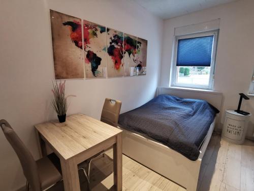 斯维斯塔尔Gemütliches Zimmer mit eigenem Bad und Küche的一间卧室配有一张床、一张桌子和一个窗户。