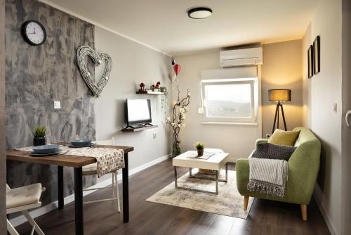 萨格勒布Apartment Viksa with Jacuzzi的客厅配有桌子和绿色椅子