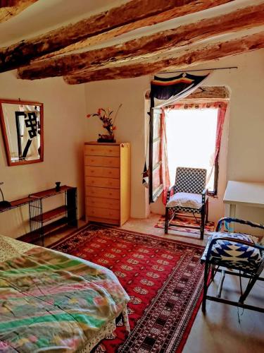 Villalba dels ArcsSidharta Room的一间卧室设有一张床、一个窗口和一把椅子