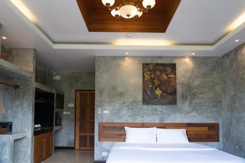 他朗Anodard Phuket, Nai Yang Beach的卧室配有一张床,墙上挂有绘画作品