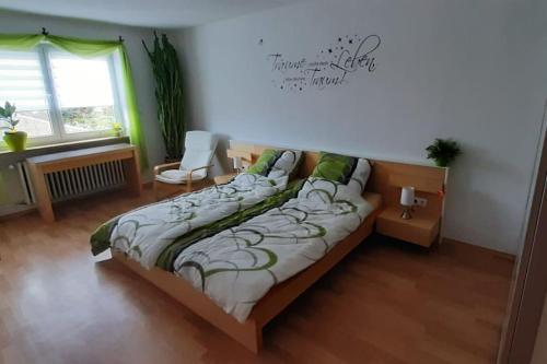 GaukönigshofenFerienwohnung Dürr的卧室配有床、椅子和窗户。