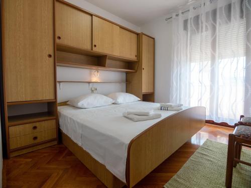 拉布德约科维奇公寓的一间卧室配有一张带木制橱柜的大床