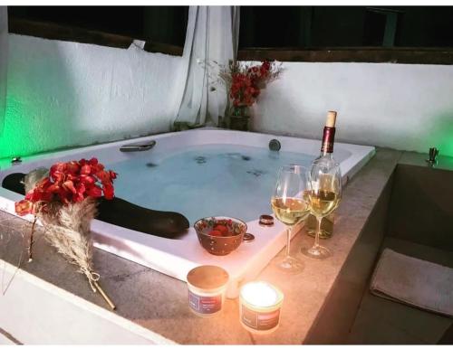 新利马Pousada Canto da Lua的浴缸配有一瓶葡萄酒和两杯酒