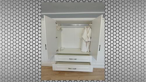 锡比乌Vi’studio的一间带大镜子和白色衣柜的浴室