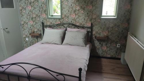 KoedijkVakantiewoning De Koolboet的一间卧室配有带粉色和白色枕头的床
