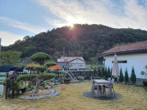 固城郡Iryang Stay的一个带桌子和遮阳伞的庭院和山地