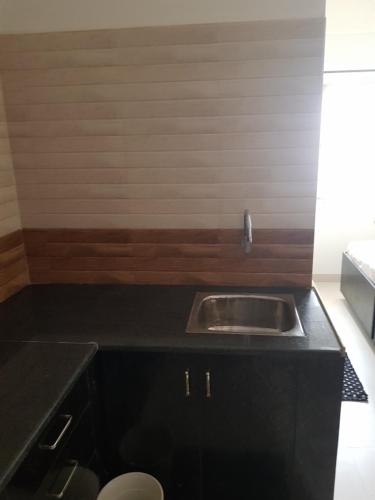 班加罗尔Anuraag的厨房配有水槽和黑色台面
