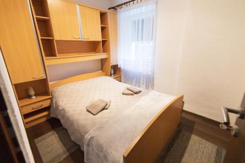 代尔尼采Apartman Mihelčić的一间小卧室,配有床和窗户