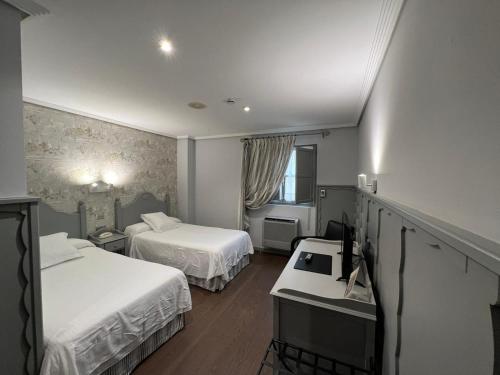 柯米拉斯科米利亚斯酒店的酒店客房配有两张床和一张书桌