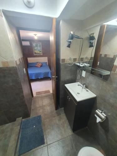 伊瓜苏港Charaí Lodge的一间带水槽和卫生间的浴室以及一张床
