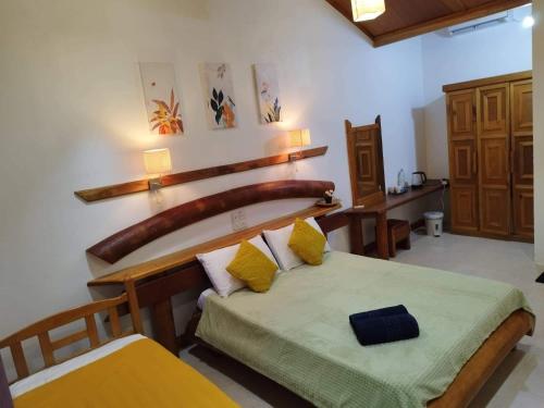 ThinadhooReethi Villa Vaavu Thinadhoo的一间卧室配有一张带木制床头板的床