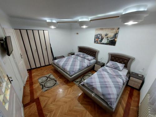 贝尔格莱德布科利昂公寓的配有2张床的木地板客房