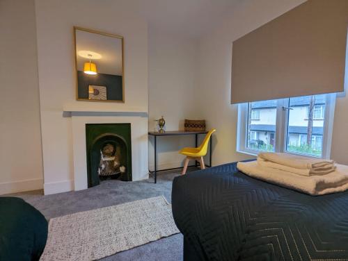 阿德尔斯通3 Bed 2 Lounge House up to 40pc off Monthly in Addlestone by Angel and Ken Serviced Accommodation Great Value for Long-term Stay的一间卧室配有一张带壁炉和镜子的床