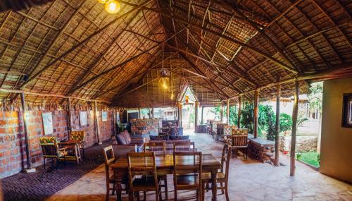 莫希Kilimanjaro Scenic Lodge的餐厅配有木桌和椅子
