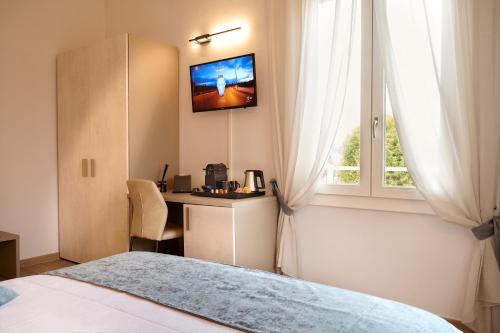博洛尼亚D'AZEGLIO 62 LUXURY ROOMS的一间卧室配有一张床、一张书桌和一个窗户。