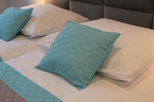 厄尔科Apartament AQUA MAZURY的一张带两个蓝色枕头的床