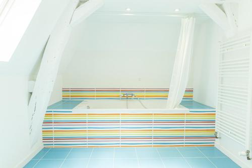 昂热Maison Bossoreil - appartement Aubance的带浴缸的浴室,铺有色彩缤纷的瓷砖地板