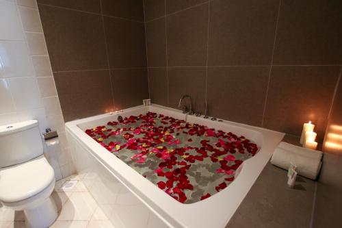 麦纳麦The Seven Hotel的浴室配有装满红花的浴缸。