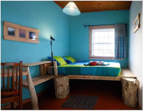 Lajes das FloresA Barraka: your cozy house in Flores!的蓝色墙壁间的一张床位