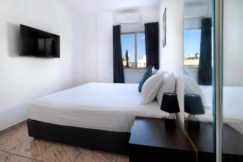 尼科西亚Urban Condo 43 - 1 Bdr的白色的卧室设有一张大床和一个窗户
