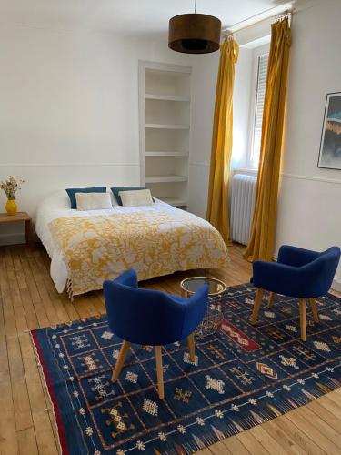 Maison chaleureuse avec piscine的一间卧室配有一张床和两张蓝色椅子