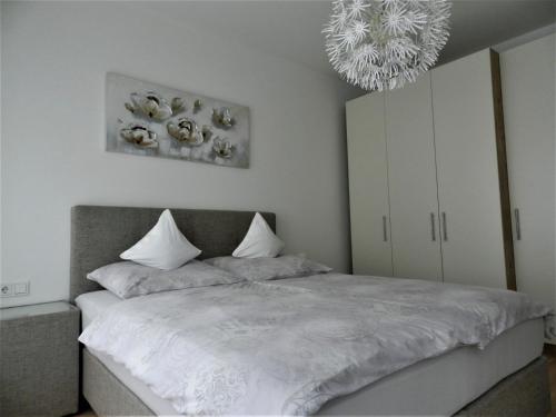 林茨Ferienwohnung DANUBIA的一间卧室配有一张床和一个吊灯