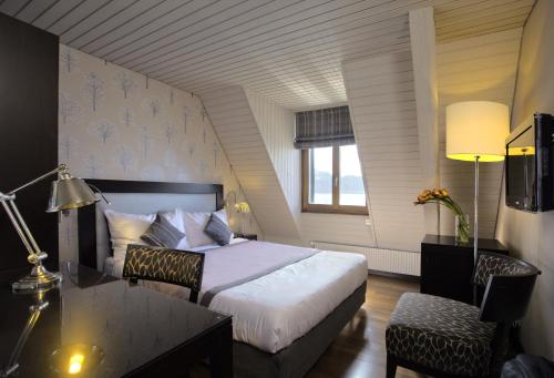 洛桑Rivage Hotel Restaurant Lutry的酒店客房配有一张床、一张桌子和一张桌子。