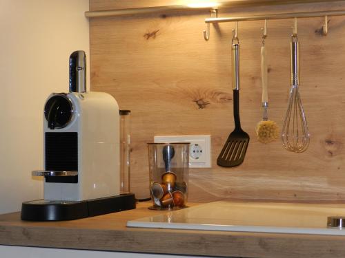 林茨Ferienwohnung DANUBIA的厨房柜台配有咖啡机和餐具