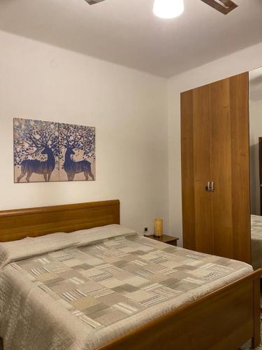 GhediCasa Andrea的卧室配有一张床,墙上挂有绘画作品