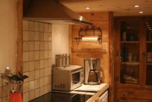 夏蒙尼-勃朗峰Three Bedroomed Chalet Apartment的厨房配有炉灶、微波炉和台面