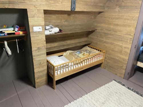 维许纳波察Chalet FiMiLi的小房间,木墙内有婴儿床
