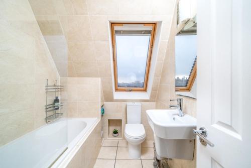 伦敦Camden Town Apartment的浴室配有盥洗盆、卫生间和浴缸。